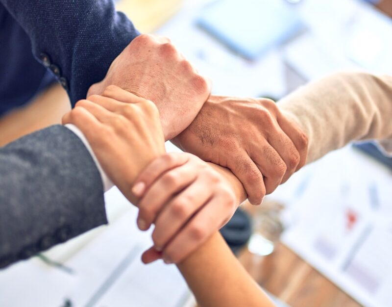 person in black long sleeve shirt holding persons hand